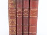 three old books sitting on top of each other on a white surface