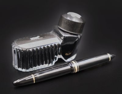 un stylo et un encrier posés sur une table