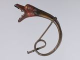 a metal sculpture of a fish on a stand