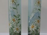 deux vases décorés de fleurs, posés sur une table
