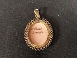 a gold plated pendant with a picture of a woman on it