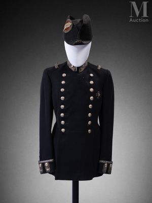 une veste militaire noire à boutons dorés et un chapeau posés sur un présentoir pour mannequin