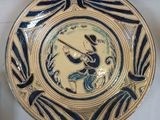 a blue and yellow plate with a picture of a bird on it