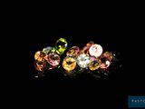 a close up of three different colored gems on a black background