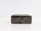 an image of a small metal object on a white surface