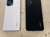 two white and black smartphones sitting side by side on a table