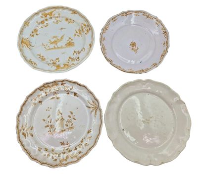 four plates with gold and white designs on them on a white surface