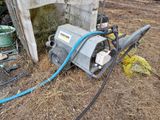 une pompe à eau posée par terre à côté d'un tas d'ordures