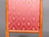 an old wooden chair with a pink and gold pattern on the back
