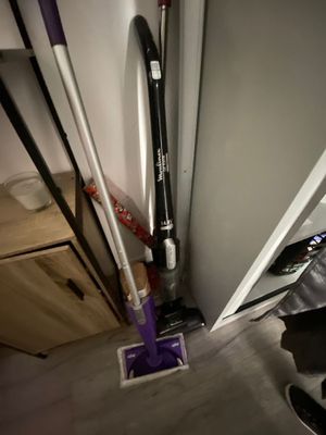 a mop that is sitting on the floor next to a vacuum
