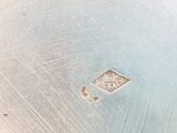 a close up of a silver plate with a diamond on it