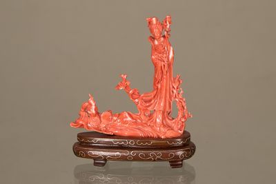 une statue représentant une femme et un oiseau, posée sur un socle