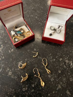 two pairs of earrings and a ring in a red box on a table