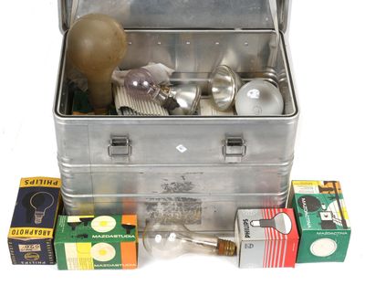 a metal box filled with various items on a white surface