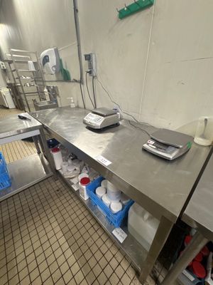 plan de travail en acier inoxydable dans une cuisine professionnelle, sur lequel est posée une balance