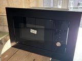 un micro-ondes posé sur une table devant une fenêtre