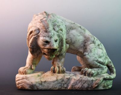 a statue of a dog that is sitting on a rock