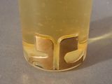 a glass with a liquid inside of it sitting on a table