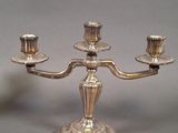 a silver candelab with three candles on it
