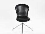 La chaise est noire, avec un piètement chromé et une assise en cuir noir.