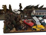 trois voitures miniatures et un bus exposés sur une table