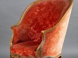 une chaise rouge avec des finitions dorées et une assise rembourrée rouge
