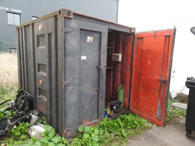 a black container with a red door next to a trash can