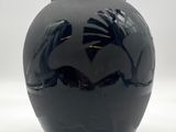 un vase noir orné d'un motif d'oiseau