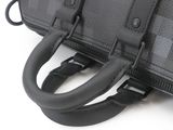 a close up of a black bag on a white surface