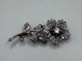 une broche en argent en forme de fleur ornée d'une libellule