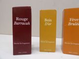 three boxes of perfume sitting on a table next to each other