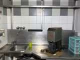 une petite cuisine avec des plans de travail en inox et un évier