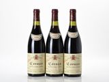 three bottles of red wine sitting on top of a white table
