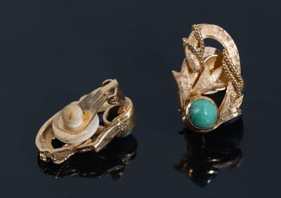pair of gold earrings with turquoise and pearl accents on a black surface