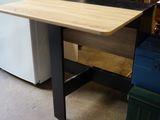 une table avec un plateau en bois posée devant un réfrigérateur