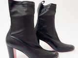 des bottines en cuir noir à semelles rouges sur fond blanc