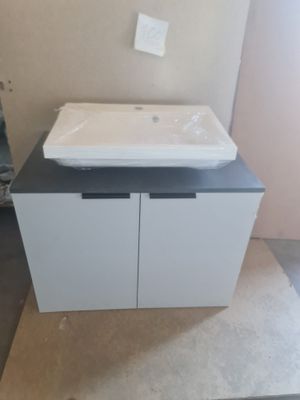 un lavabo blanc posé sur un plan de travail dans une salle de bains