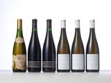 six bottles of wine lined up in a row on a table