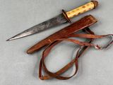 a knife and a leather sheath on a table