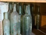 de nombreuses bouteilles vides posées sur une étagère dans une pièce