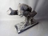 a sculpture of a bear that is sitting on a branch