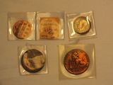 four different types of coins in plastic bags on a table