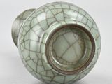 a small green vase with a cracky design on it