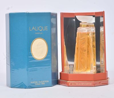l'image d'un flacon de parfum posé à côté d'une boîte