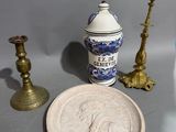 trois bougies et une petite assiette posées sur une table