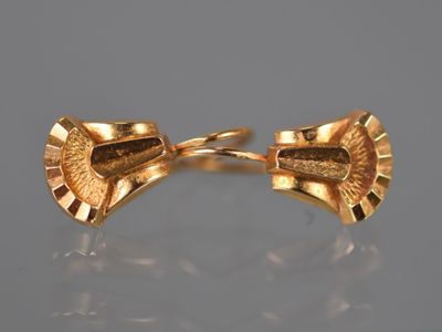 une paire de boutons de manchette dorés ornés d'un motif en éventail
