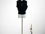 mannequin with black shirt and hat on stand next to a vase