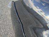 a close up of a car ' s hood with a reflection of clouds in the hood