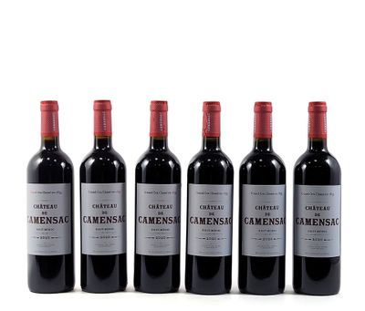 four bottles of wine are lined up on a white surface