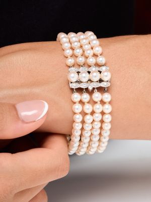 une personne portant un bracelet orné de perles et une bague en diamant au poignet
